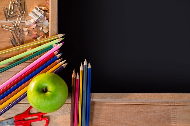 Foto gratuita primo piano della lavagna con la matita colorata e mela