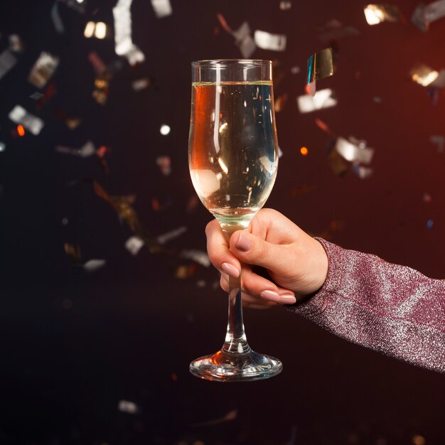 Close-up champagne glass with confetti