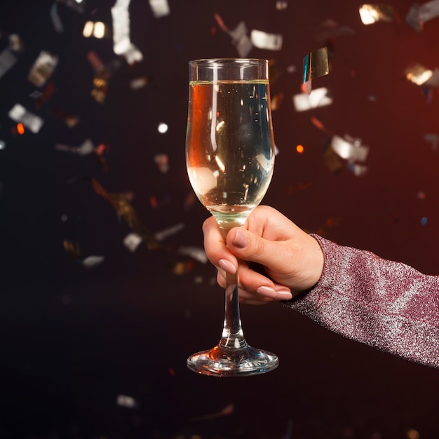 Close-up champagne glass with confetti