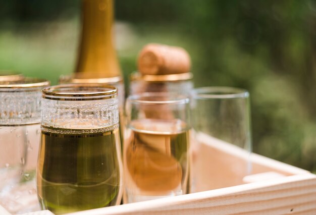 Close-up of champagne glasses in wooden crate