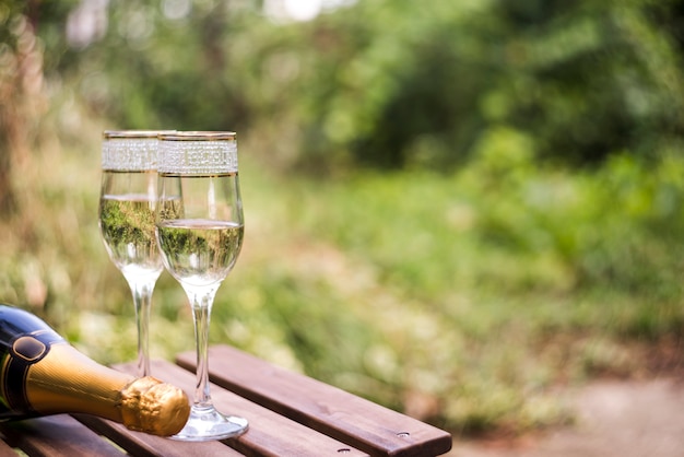 Close-up of champagne glasses on wooden table at outdoors