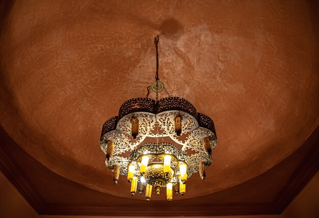 Close up of a chandelier on the ceiling with a traditional oriental style with many details