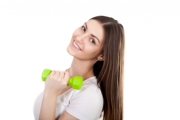 Close-up of cheerful girl posing with a green dumbbell