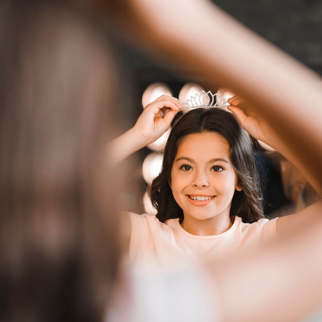 Foto gratuita primo piano della ragazza allegra che indossa la corona del diamante