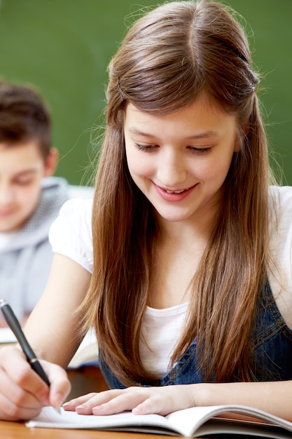 Close-up of cheerful student doing homework