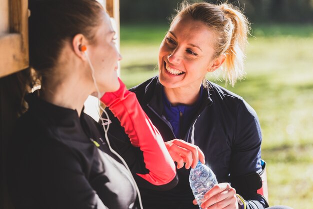 Close-up of cheerful woman holding a water bottle