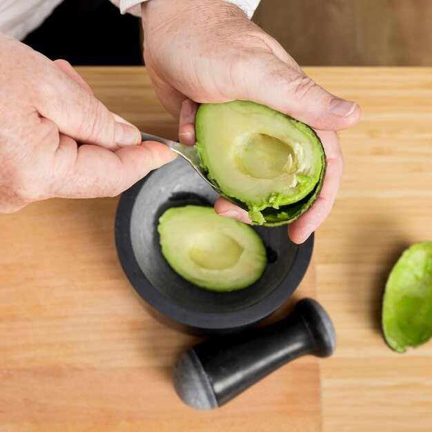 Close-up chef cleaning avocado