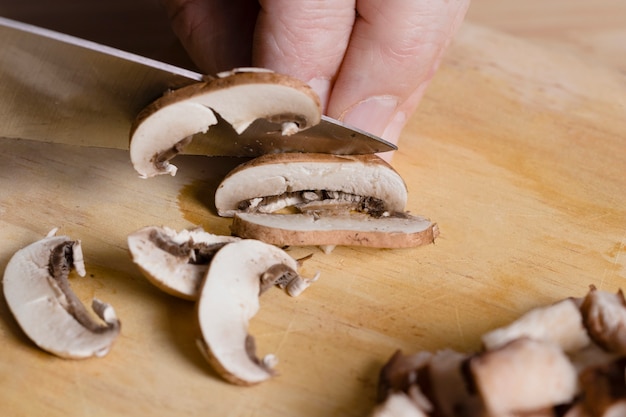 Free photo close up chef cutting mushrooms