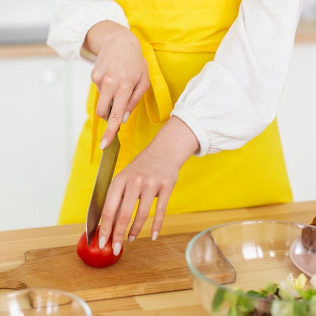 Close-up chef cutting tomato