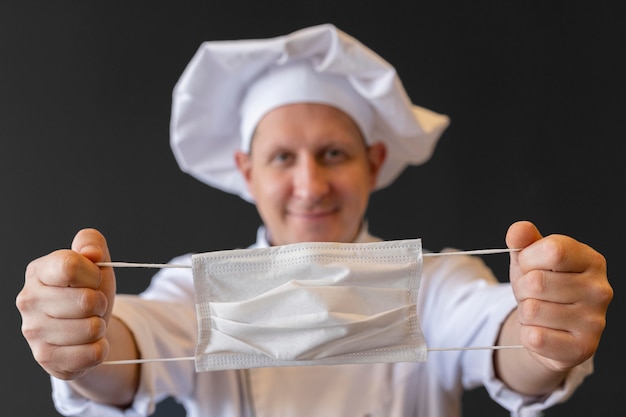 Close-up chef holding medical mask