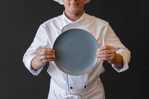 Close-up chef holding plate