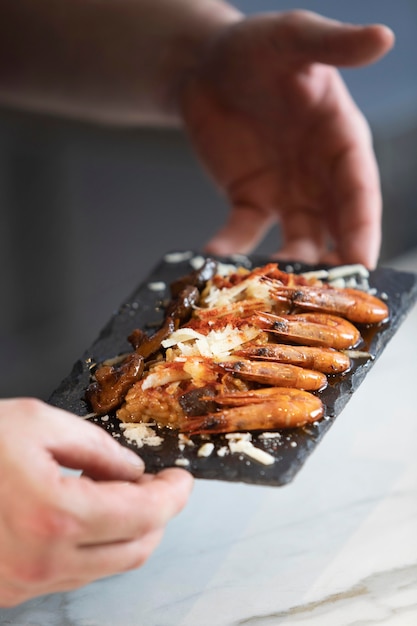 Foto gratuita chiuda sul cuoco unico che prepara il piatto dell'alimento