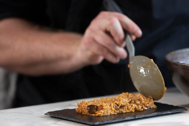 Foto gratuita chiuda sul cuoco unico che prepara il piatto dell'alimento