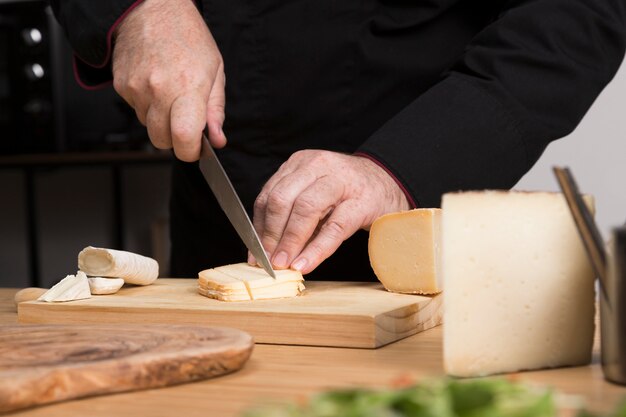 Close-up chef slicing cheese