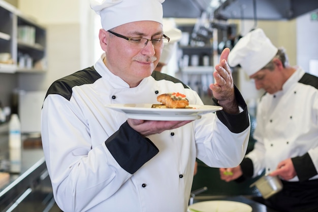 Primo piano su chef annusare il piatto dopo la cottura