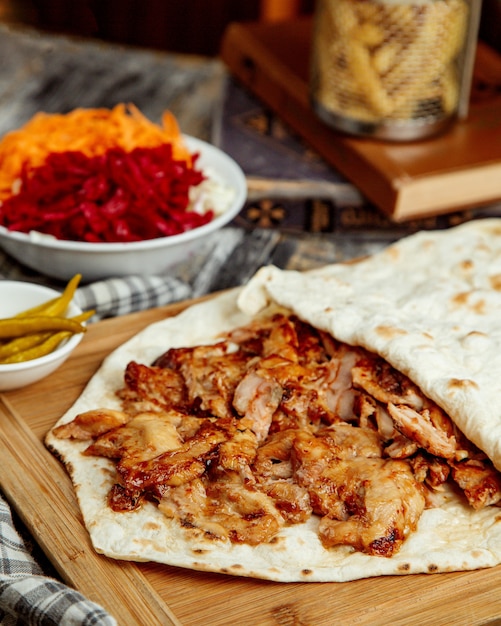 Close up of chicken doner slices placed between flatbread