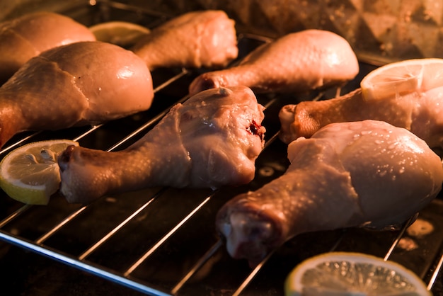 Close-up of a chicken drumsticks arranged on metal grill