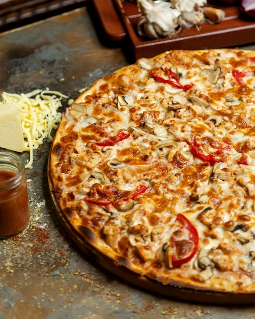 Close up of chicken pizza with tomato mushroom and cheese