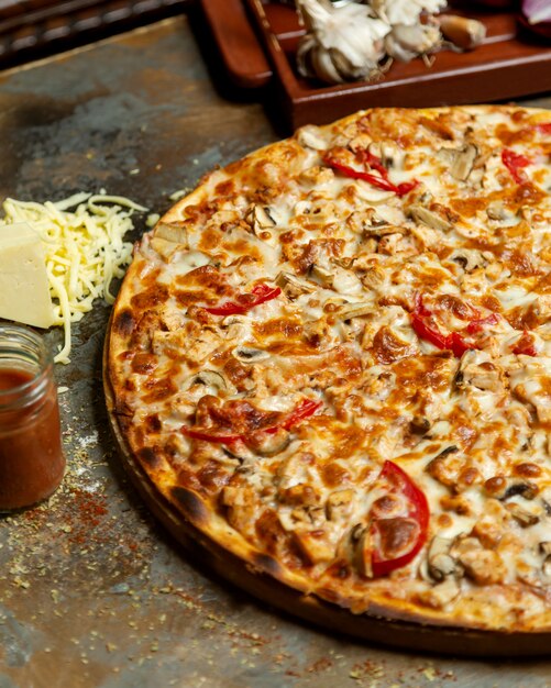 Крупный план куриной пиццы с томатным грибом и сыром