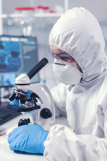 コロナウイルス実験時に顕微鏡を調整する主任研究員のクローズアップ