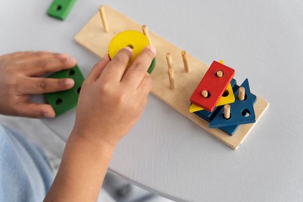 Foto gratuita primo piano sul bambino che si diverte con il gioco didattico