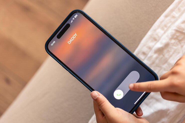 Free Photo close up of child hands holding phone with dads incoming call on display