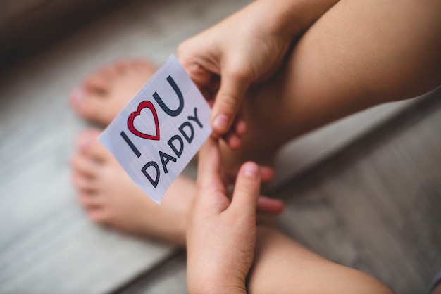 Close-up of child holding a note for father's day