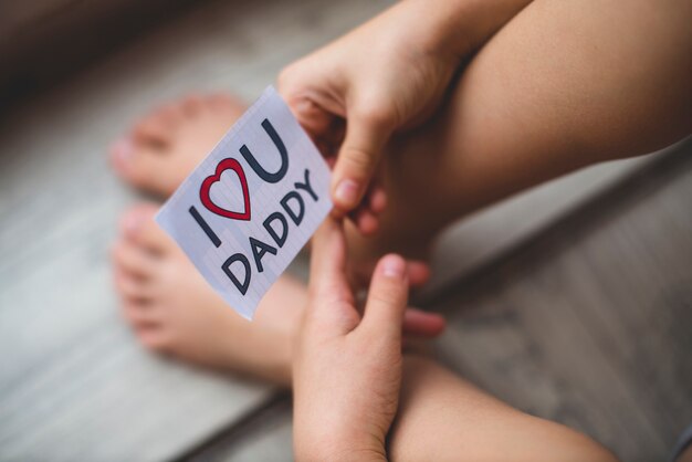 Крупный план ребенка держит записку за день отца