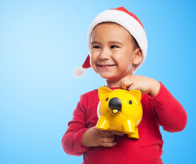 Free photo close-up of child holding a piggybank with blue background