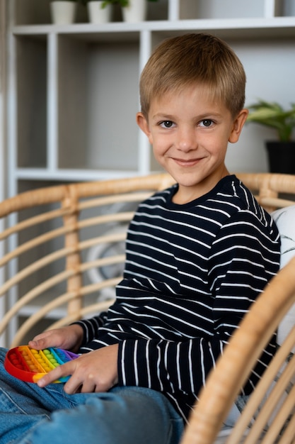 Foto gratuita primo piano sul bambino che gioca con il giocattolo pop it