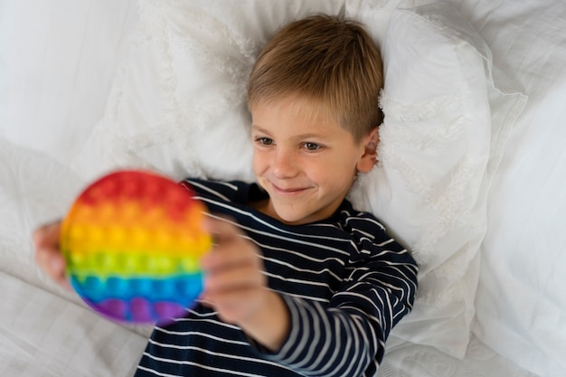 Foto gratuita primo piano sul bambino che gioca con il giocattolo pop it