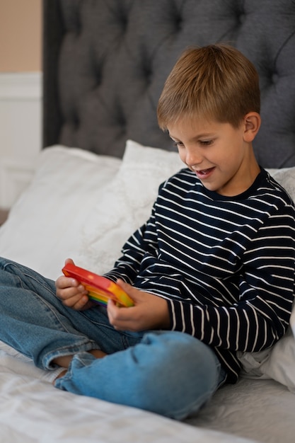 Foto gratuita primo piano sul bambino che gioca con il giocattolo pop it