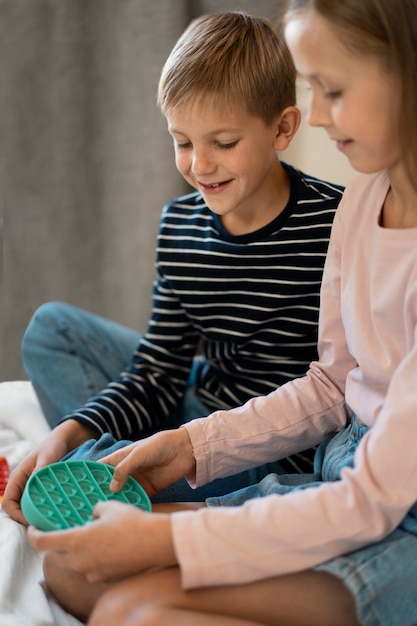 Foto gratuita primo piano sul bambino che gioca con il giocattolo pop it