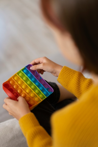 Foto gratuita primo piano sul bambino che gioca con il giocattolo pop it