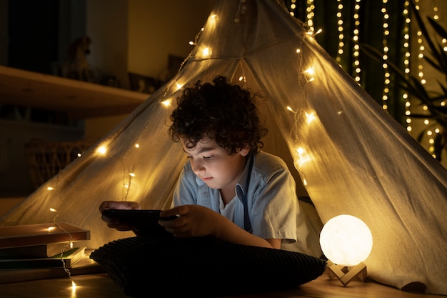 Close up on child reading in his house tent