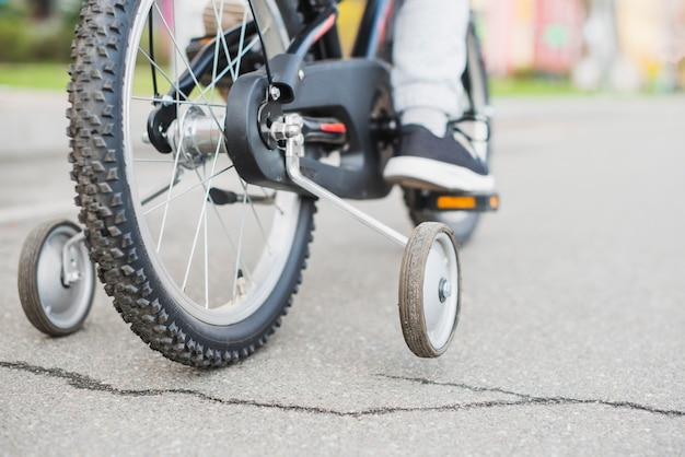 Close up of child riding bike outside