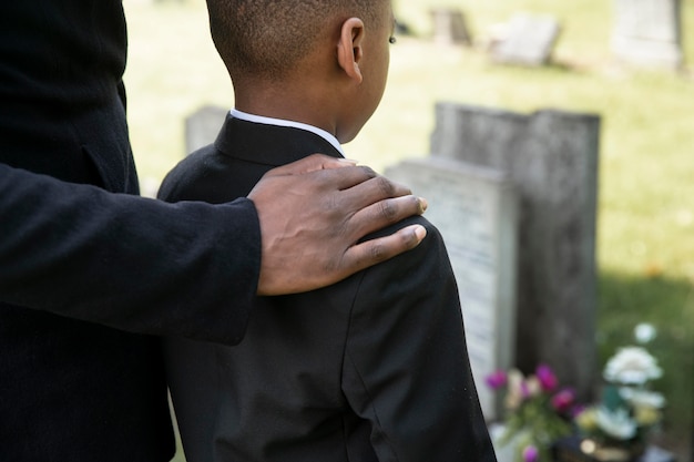 Close up on child visiting the grave of loved one