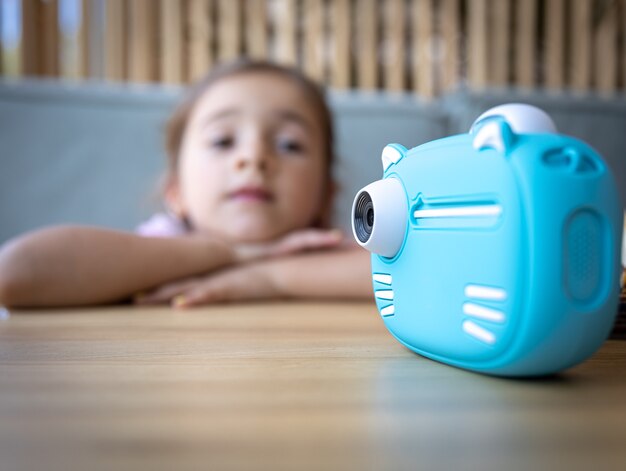 즉석 사진 인쇄를 위한 어린이용 파란색 장난감 카메라의 클로즈업.