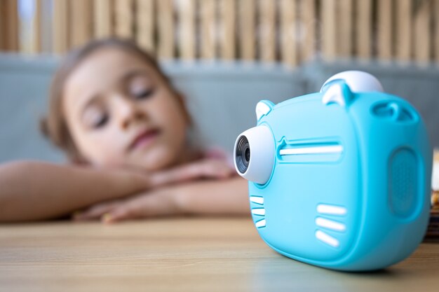 Close-up of children's blue toy camera for instant photo printing.