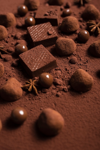 Free photo close up chocolate waffles and truffles on cocoa powder