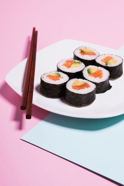 Close-up chopsticks on plate near sushi