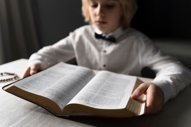 聖書を読んでいるキリスト教の少年をクローズアップ
