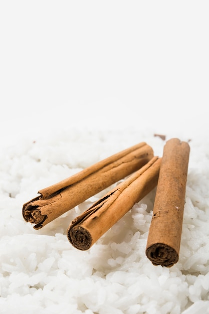 Close-up of cinnamon sticks on steamed white rice
