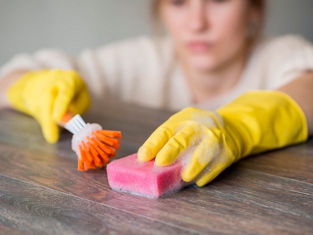 Foto gratuita pulitore del primo piano che disinfetta con la spugna