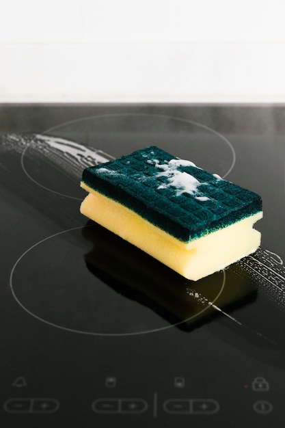 Close up cleaning sponge on induction stove