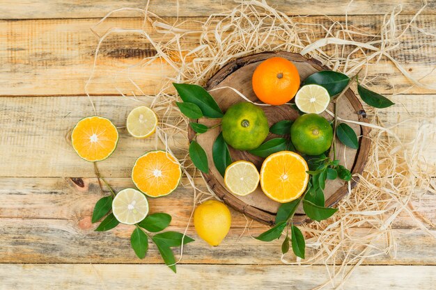 Close-up clementines on wooden board with limes and tangerines on wooden board