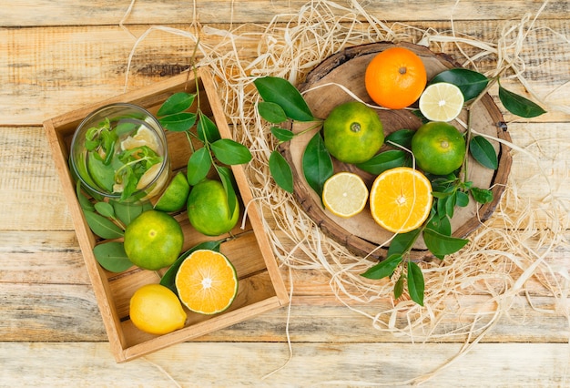 Foto gratuita clementine del primo piano in una cassa di legno con i mandarini sulla tavola di legno