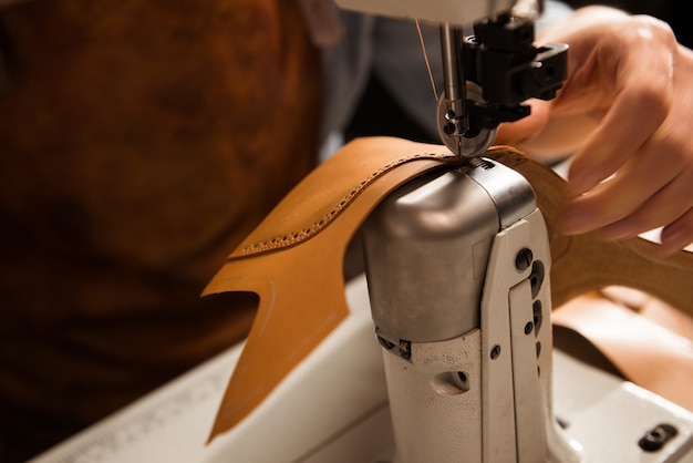 Free photo close up of a cobbler stitching a part of shoe