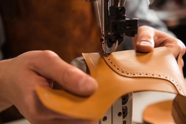 Крупным планом сапожник шить часть обуви