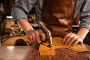 Free photo close up of a cobbler working with leather